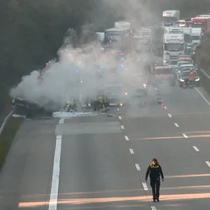 Dicker Rauch zieht von einem Auto auf, dahinter staut sich der Verkehr der A7