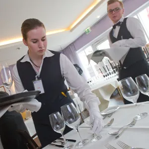 Junge Frau deckt Tisch in Hotel