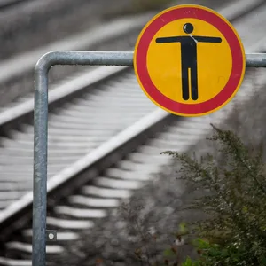 Warnschild vor leeren Bahngleisen