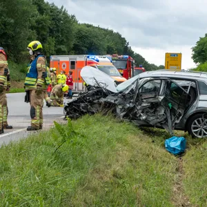 Einsatzkräfte vor einem der zwei am Unfall beteiligten Fahrzeuge.