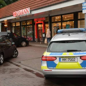 Blick auf eine Rossmann-Filiale, davor ein Polizeiauto