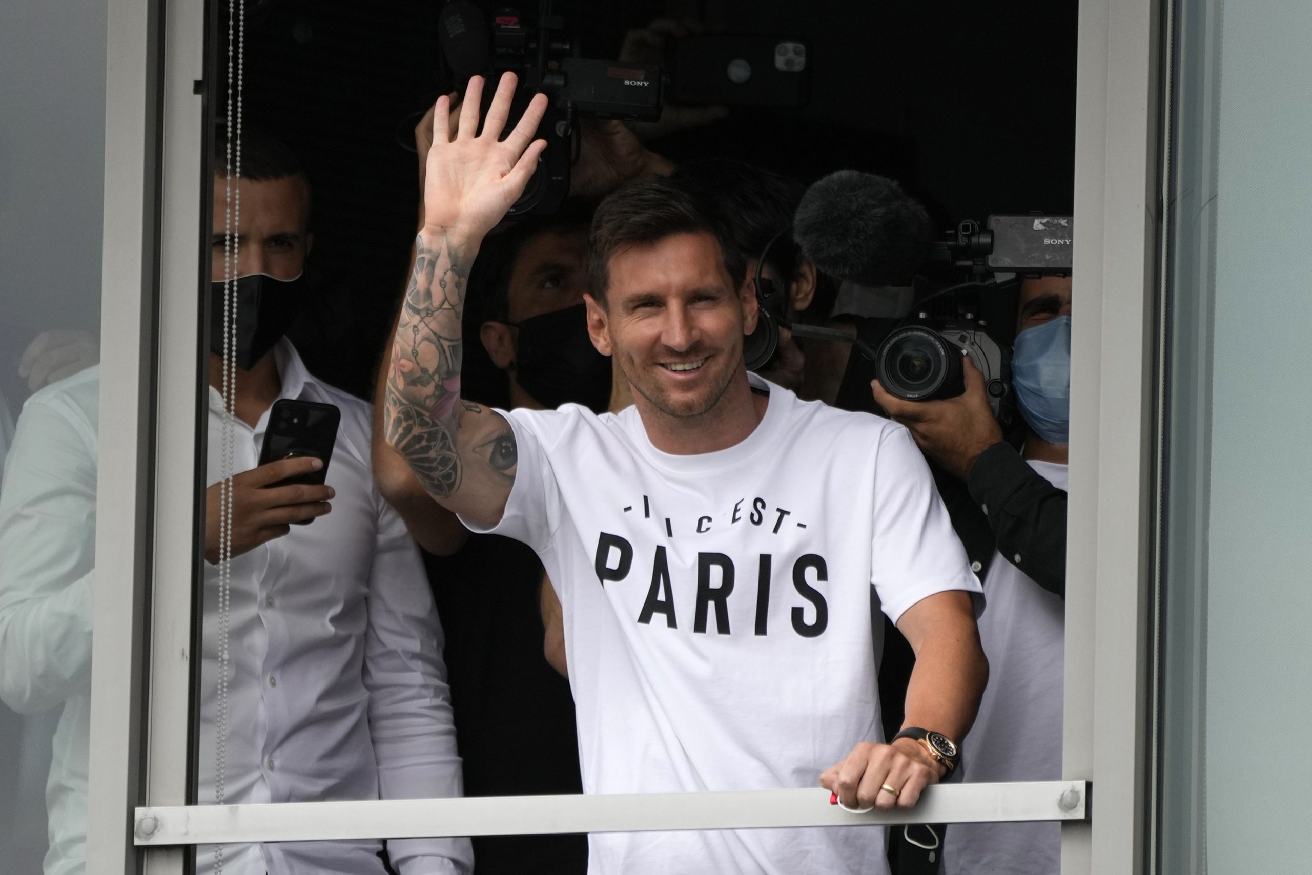 Lionel Messi winkt den Pariser Fans nach seiner Landung zu.