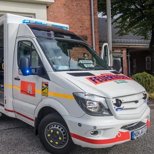 Zwei Notfallsanitäter bereiten sich auf einen Einsatz mit dem E-Rettungswagen vor.
