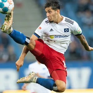 Ludovit Reis streichelt in der Luft mit dem Fuß den Ball.