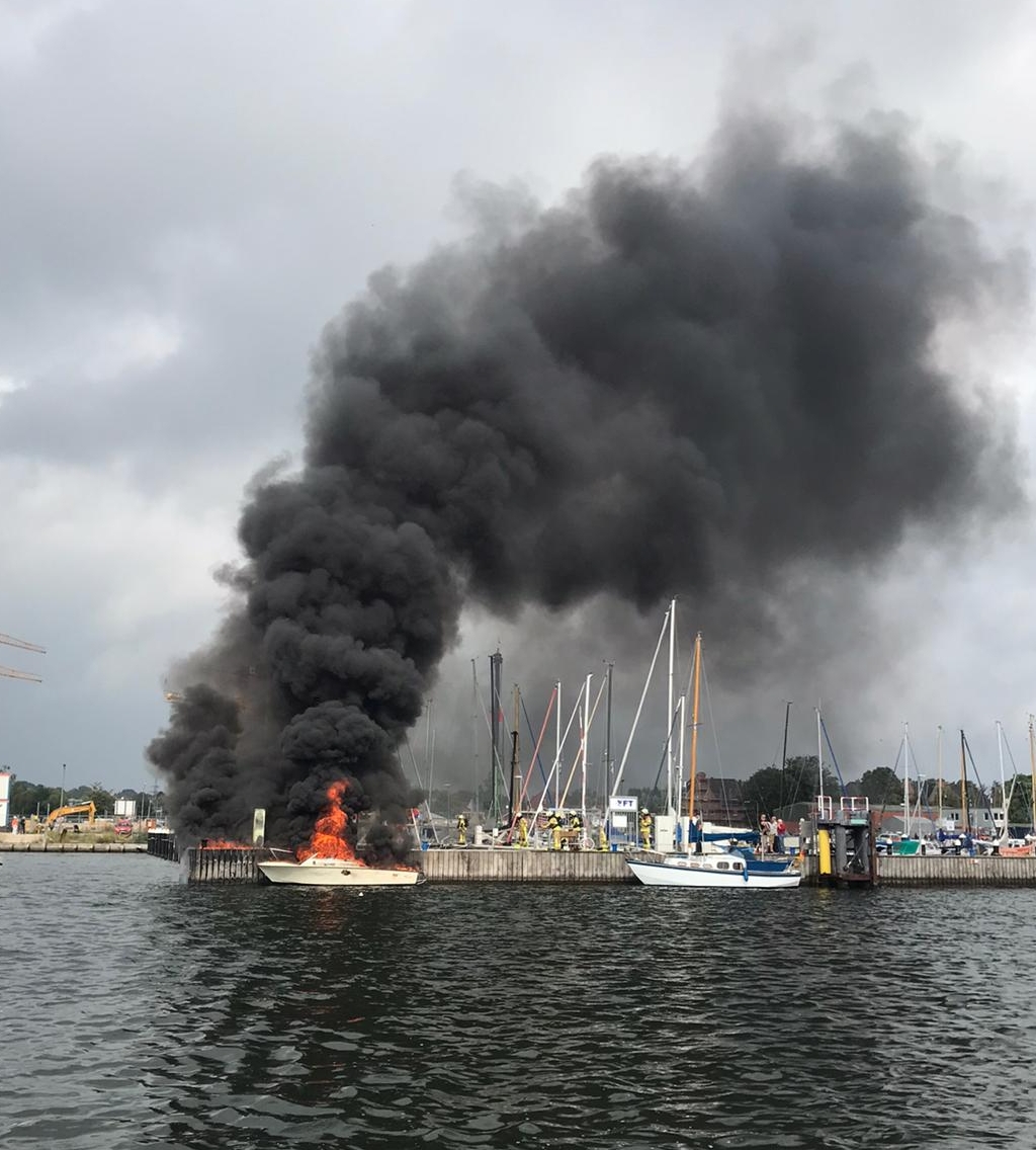 Ein Motorboot treibt brennend in Lübeck auf der Trave.