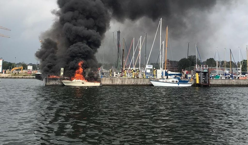 Ein Motorboot treibt brennend in Lübeck auf der Trave.