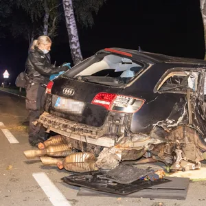 Eine Polizistin am durch den Unfall beschädigten Audi.
