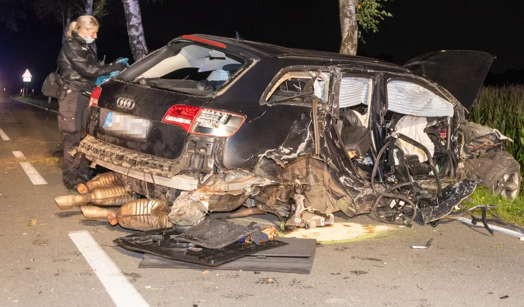 Eine Polizistin am durch den Unfall beschädigten Audi.