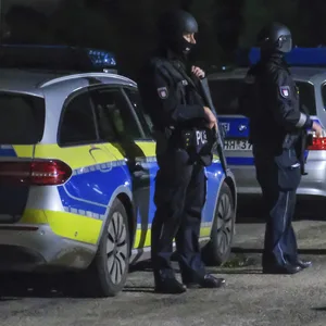 Polizisten in schusssicherer Ausrüstung durchsuchen eine Kleingartenkolonie in Hamburg-Bergedorf.