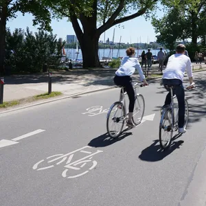 Radfahrer fahren auf der Fahrradstraße an der Außenalster auf der Veloroute 4.