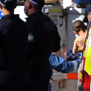 Der Dreijährige wird an einem Krankenwagen getragen, bevor er ins Krankenhaus gebracht wird.