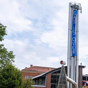 Ein Plakat von Umweltaktivisten mit der Aufschrift „Gas is Over“ hängt am 30 Meter hohen Kraftwerk-Schornstein.