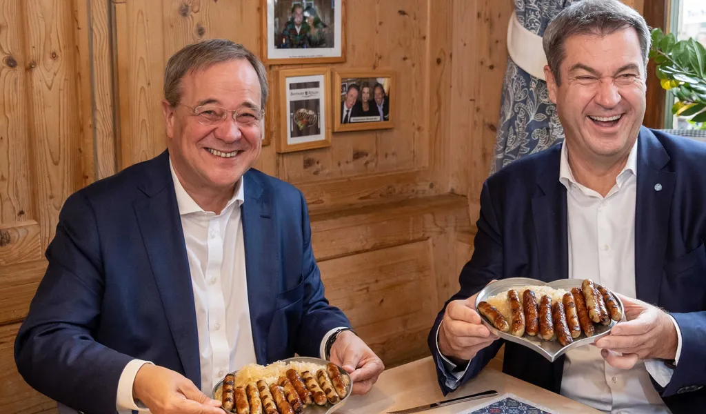 Markus Söder (r), CSU-Parteivorsitzender und Ministerpräsident von Bayern, und Armin Laschet, Unions-Kanzlerkandidaten, CDU-Vorsitzender und Ministerpräsident von Nordrhein-Westfalen, essen zusammen in einem Bratwurst-Restaurant Nürnberger Würstchen