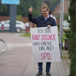 SPD-Politiker hält Wahlplakat in der Hand