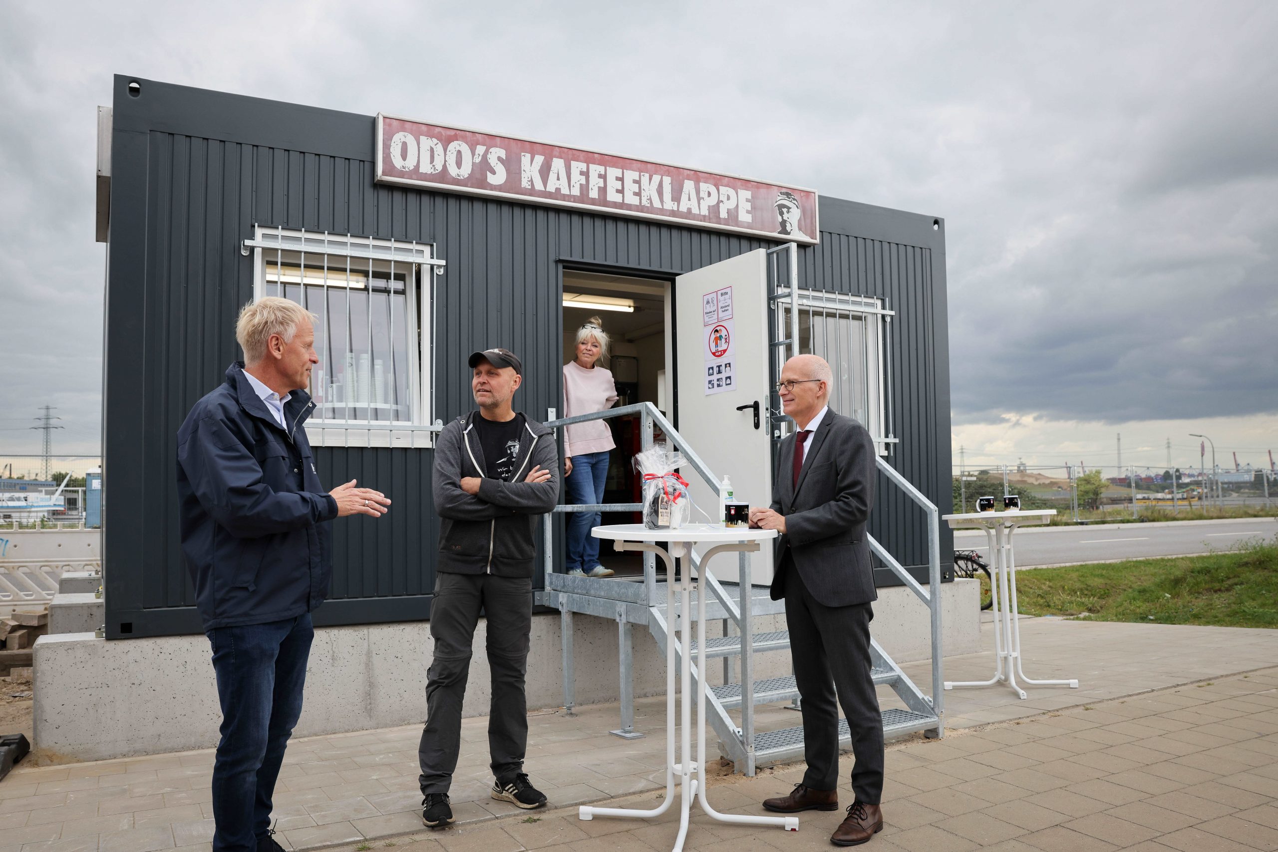Die Kaffeeklappe von Odo Wehr (M.) feiert Wiedereröffnung. Jens Meier (l.), Geschäftsführer der Hamburg Port Auhtority (HPA), Bürgermiester Peter Tschentscher (SPD) gratulieren.