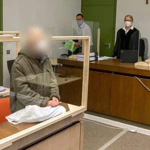 Der Angeklagte steht zum Prozessauftakt an seinen Platz im Gerichtssaal des Landgerichts München I.