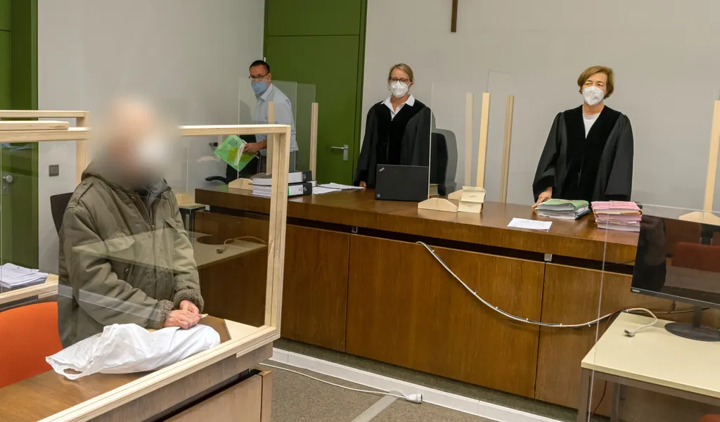 Der Angeklagte steht zum Prozessauftakt an seinen Platz im Gerichtssaal des Landgerichts München I.