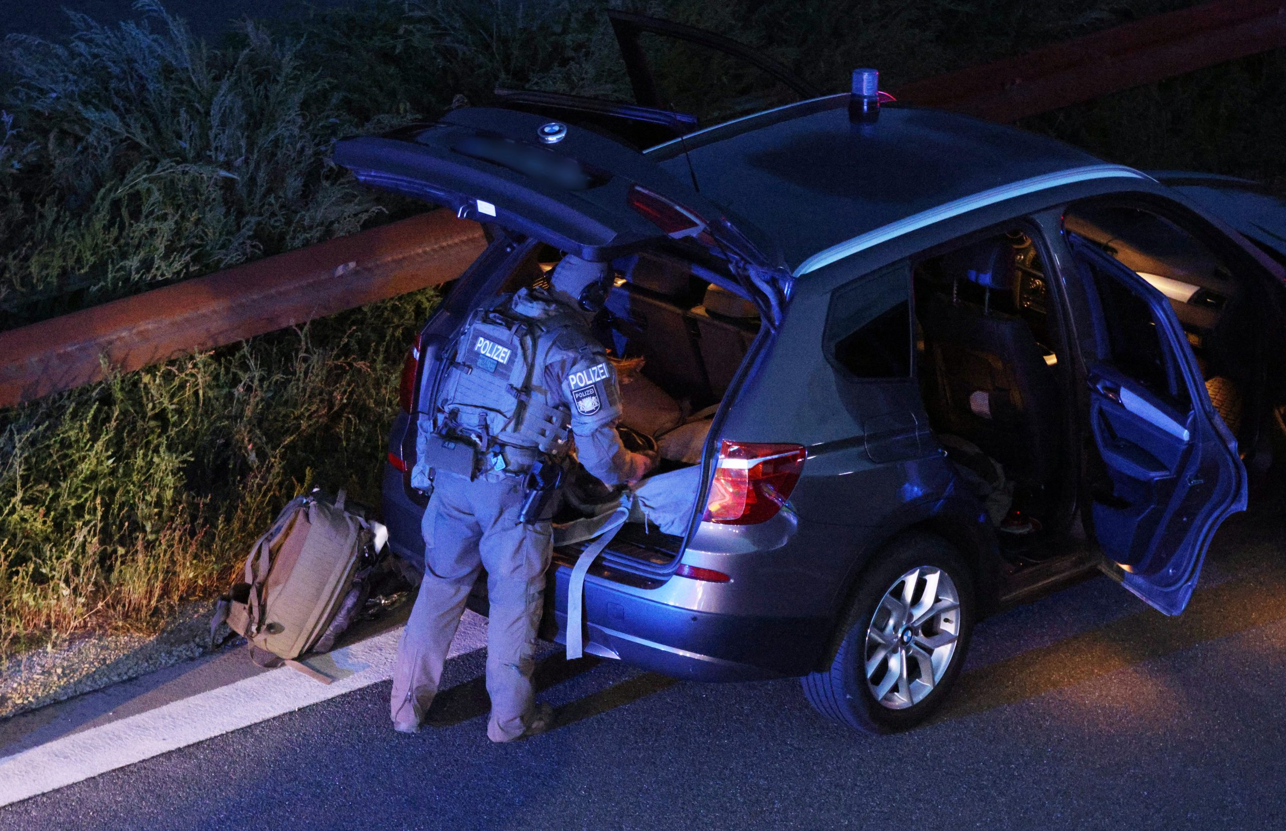Ein Polizist mit Spezialausrüstung steht an einem Fahrzeug auf der Autobahn 9.