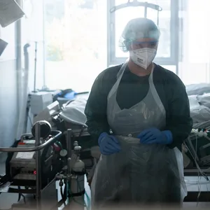 Eine Mitarbeiterin der Pflege steht in einem Patientenzimmer der Corona-Intensivstation des Universitätsklinikums Essen.