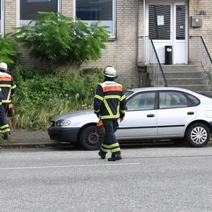 Mehrere Feuerwehrleute stehen vor einem Bürogebäude in Hamm