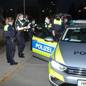 Zahlreiche Polizisten an einem Polizeiauto