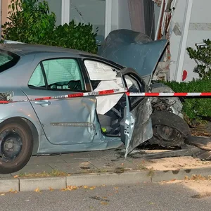 Ein Polizist vor dem Renault Laguna und dem für unbewohnbar erklärten Haus.
