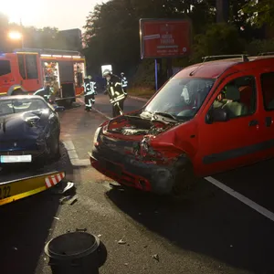 Die beiden zerstörten Pkw stehen auf der Straße vor einem Einsatzfahrzeug.