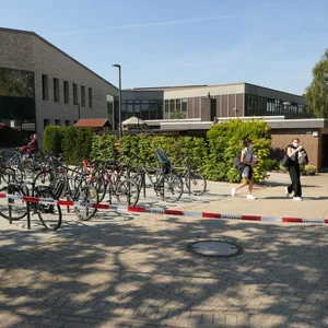 Flatterband der Polizei hängt vor der Schule, Kinder verlassen das Gelände