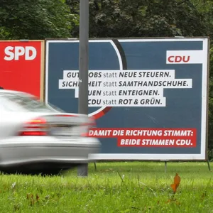 Ein Wahlplakat der SPD mit dem Konterfei von Kanzlerkandidat Olaf Scholz steht neben einem Wahlplakat der CDU an einer Straße in Barmbek.