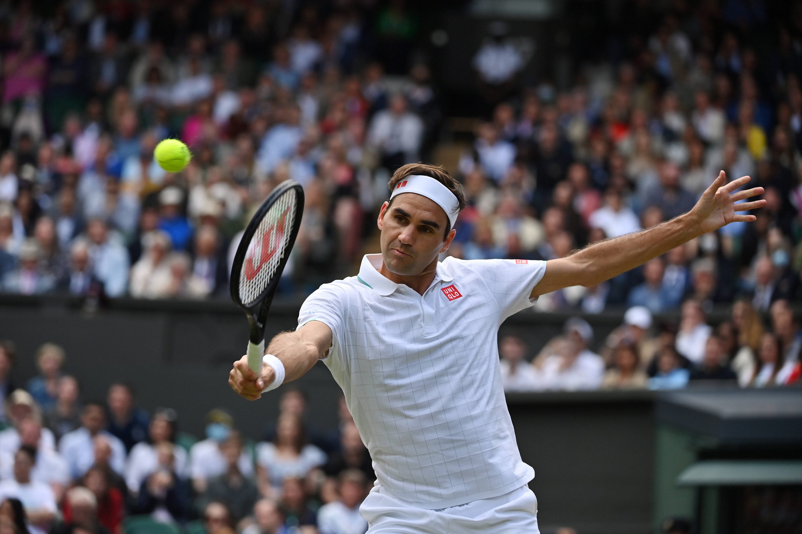 Roger Federer trifft den Ball mit der Rückhand.