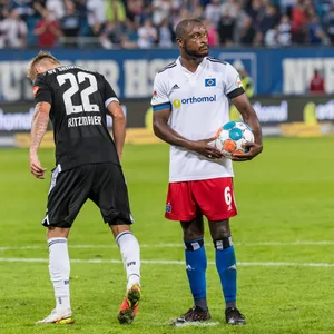 Während Marcel Ritzmaier mit dem Fuß den Elfmeterpunkt bearbeitet, steht David Kinsombi seelenruhig mit dem Ball in der Hand da und wartet.