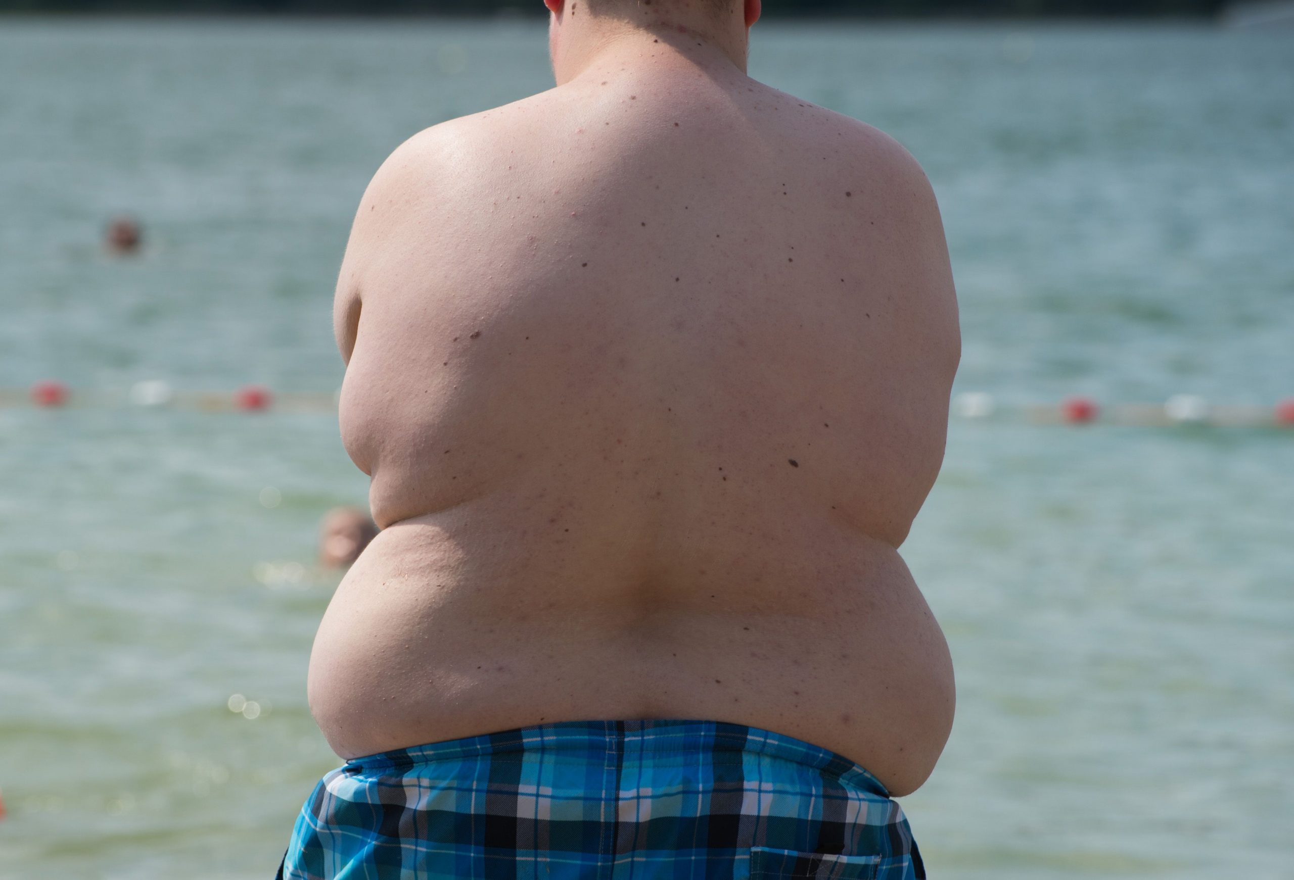 Ein übergewichtiges Kind am See.