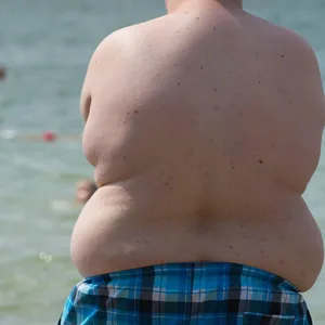 Ein übergewichtiges Kind am See.