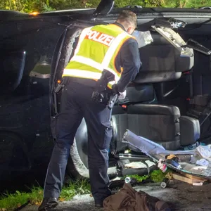 Rettungskräfte vor dem BMW, der aufgeschnitten werden musste, um die Frau zu befreien.