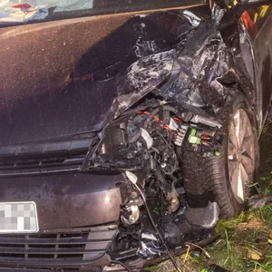 Einsatzkräfte neben dem beschädigten Volkswagen.