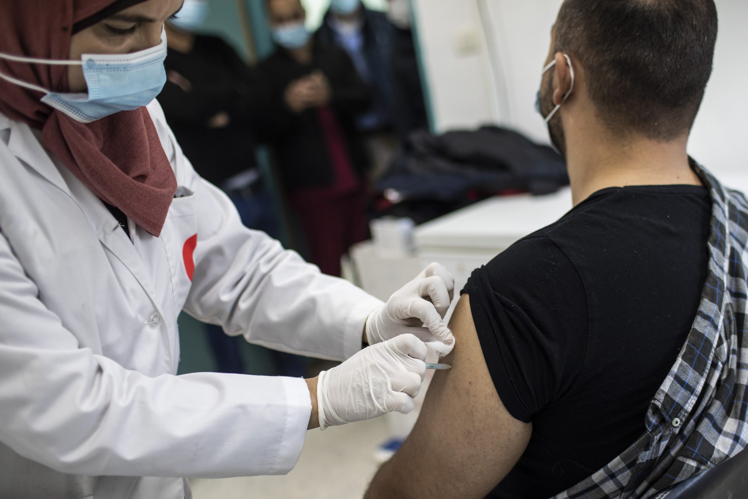 Eine medizinische Mitarbeiterin verabreicht einem Kollegen eine Corona-Impfung in einem Impfzentrum des palästinensischen Gesundheitsamtes.