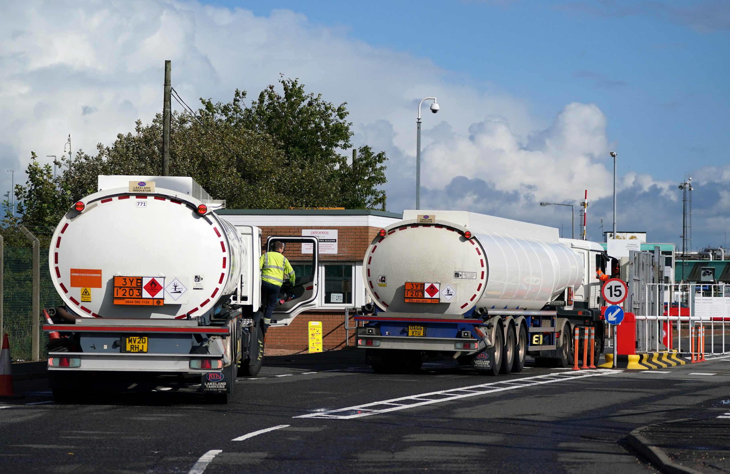 Kraftstofftankwagen stehen vor der Einfahrt der Petroineos-Raffinerie in Grangemouth auf einer Straße. Die britische Regierung ist unter enormen Druck, den Lkw-Fahrermangel zu beheben.