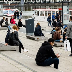 Menschen sitzen am Alsteranleger am Jungfernstieg