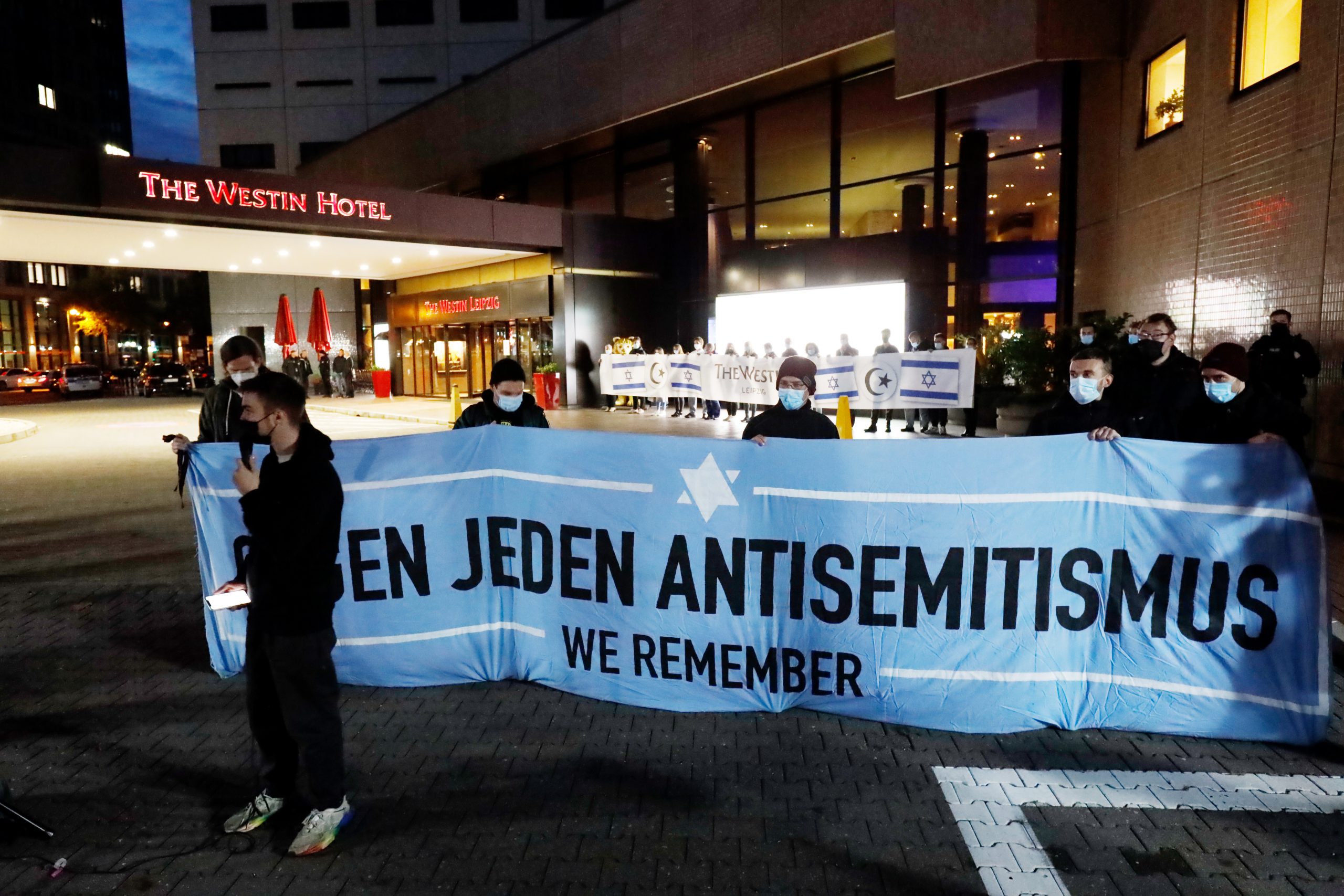 Teilnehmer einer Demonstration des Bündnis „Leipzig nimmt Platz“ stehen vor dem „Westin Hotel” Leipzig. Nach Antisemitismus-Vorwürfen haben sich am Abend Hunderte Menschen versammelt, um Solidarität mit dem Musiker Gil Ofarim und Jüdinnen und Juden in Deutschland zu zeigen.