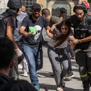Schüsse in Beirut: Zivilisten und medizinisches Personal laufen über eine Straße, um sich zu schützen.