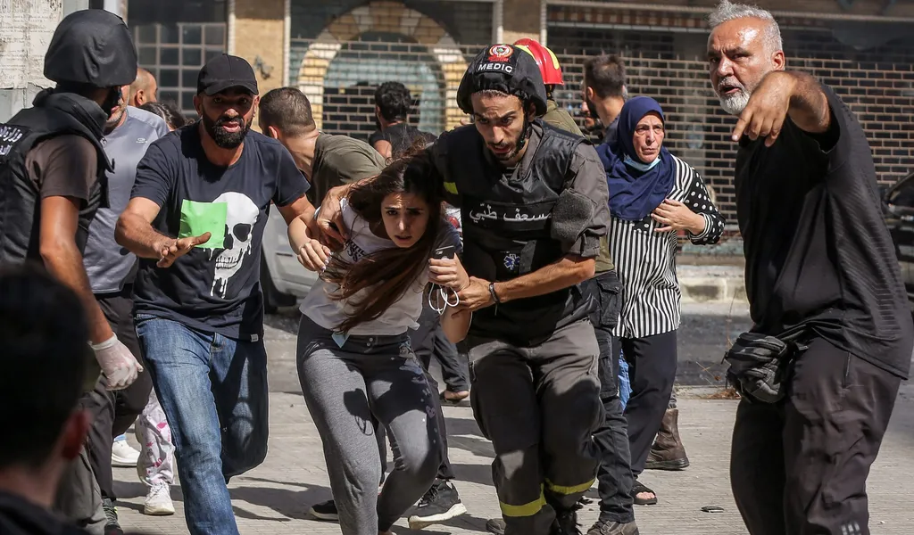 Schüsse in Beirut: Zivilisten und medizinisches Personal laufen über eine Straße, um sich zu schützen.