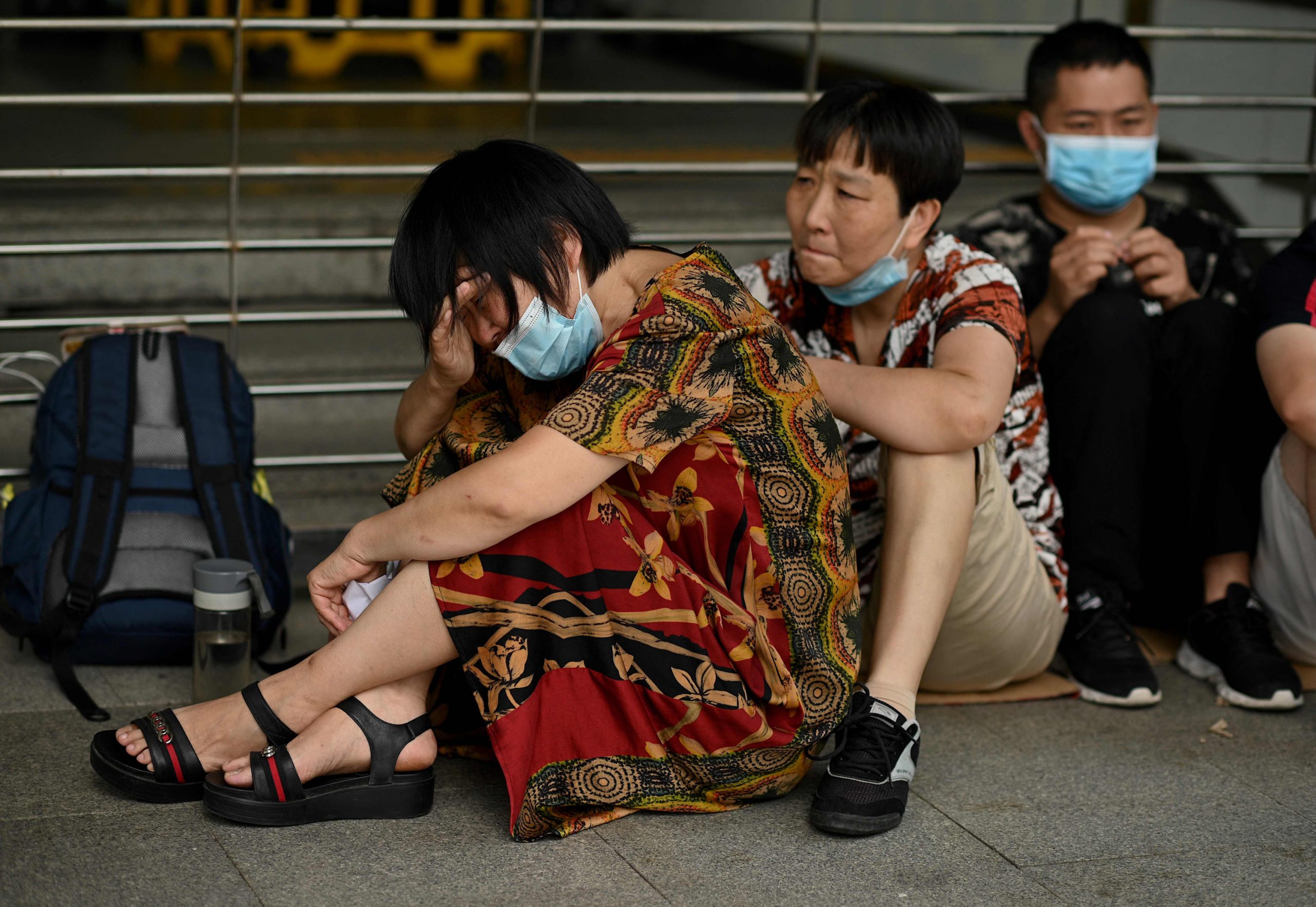 Chinesinnen sitzen weinend am Boden.