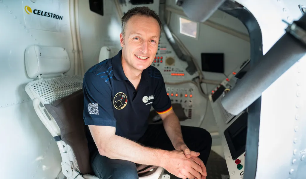 Matthias Maurer sitzt in einer nachgebauten Apollo 13 Raumkapsel.