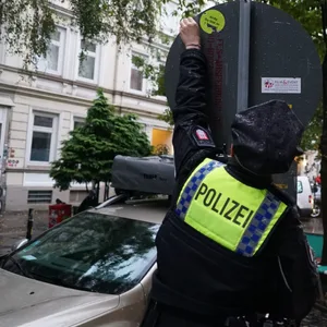Ein Polizist greift nach einem Aufkleber