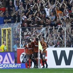 St. Paulis Spieler und die mitgereisten Fans bejubeln St. Paulis letzten Sieg in Freiburg im August 2010.