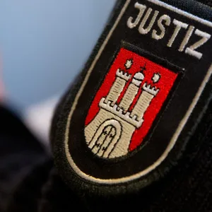 Ein Justizbeamter steht vor einem Gerichtssaal im Strafjustizgebäude.
