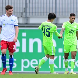 Während Moritz Heyer (l.) missmutig dreinblickt, empfängt Wolfsburgs Lukas Nmecha (r.) Glückwünsche für eines seiner drei Testspiel-Tore gegen den HSV.