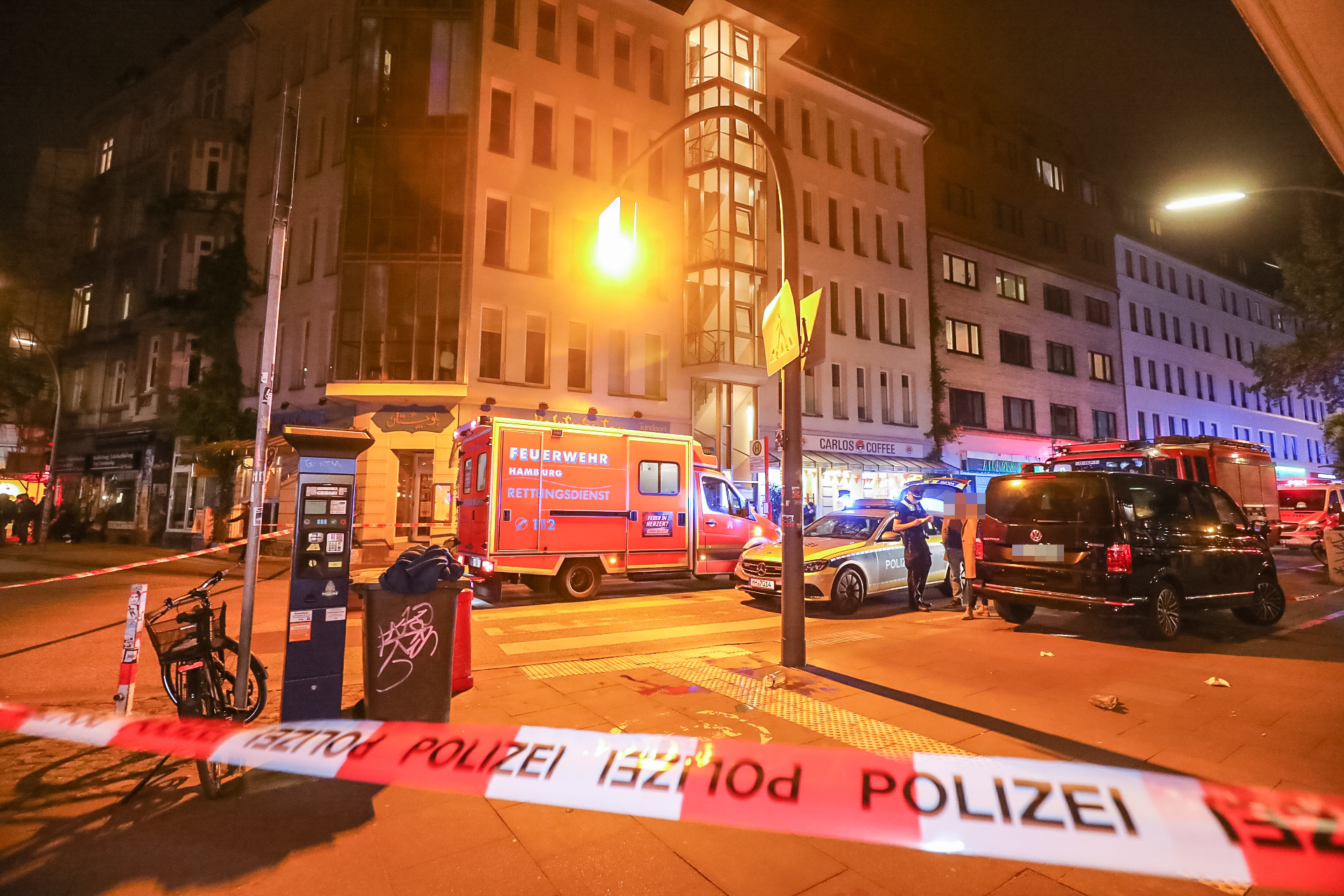 Polizisten befragen am Tatort in Hamburg-Ottensen Zeugen, haben den Bereich abgesperrt.