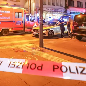 Polizisten befragen am Tatort in Hamburg-Ottensen Zeugen, haben den Bereich abgesperrt.