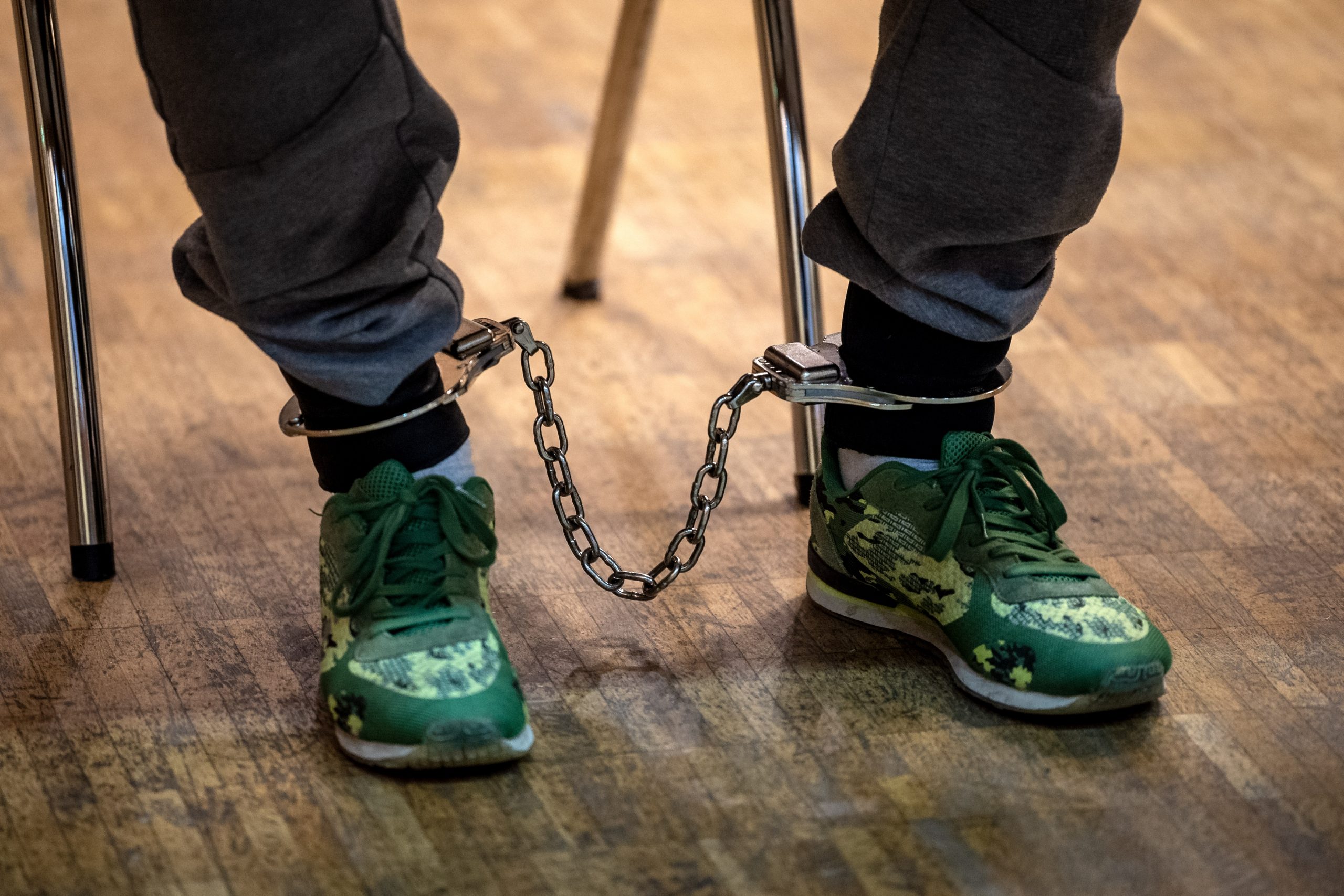 Einer der Angeklagten im Mordprozess sitzt mit Fußfesseln in der Stadthalle Verden (Archivbild vom 18. Oktober).